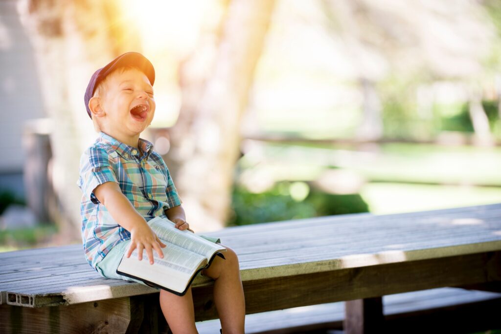 Kid laughing holding the Bible